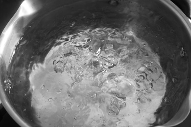 Pot with boiling water on stove, closeup