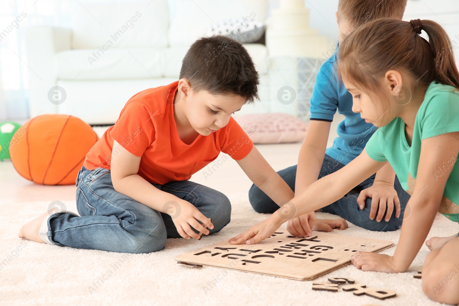 Photo of Cute little children playing together on floor, indoors