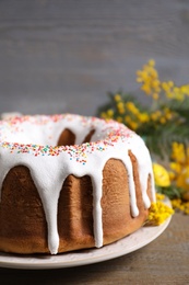 Glazed Easter cake with sprinkles on wooden table, closeup