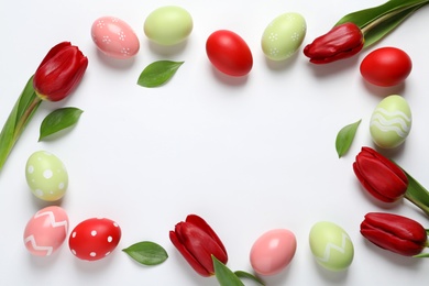 Flat lay composition of painted Easter eggs on white background, space for text