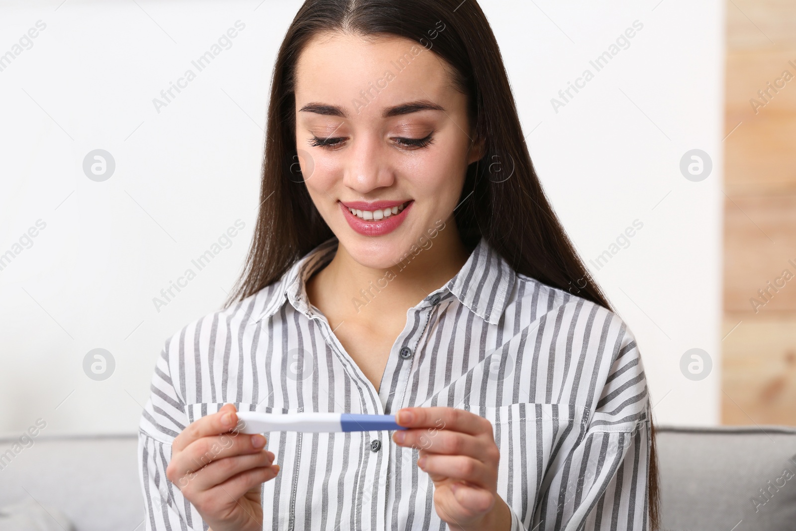 Photo of Young woman with pregnancy test at home. Gynecology and childbirth