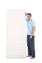 Young man with comfortable mattress isolated on white