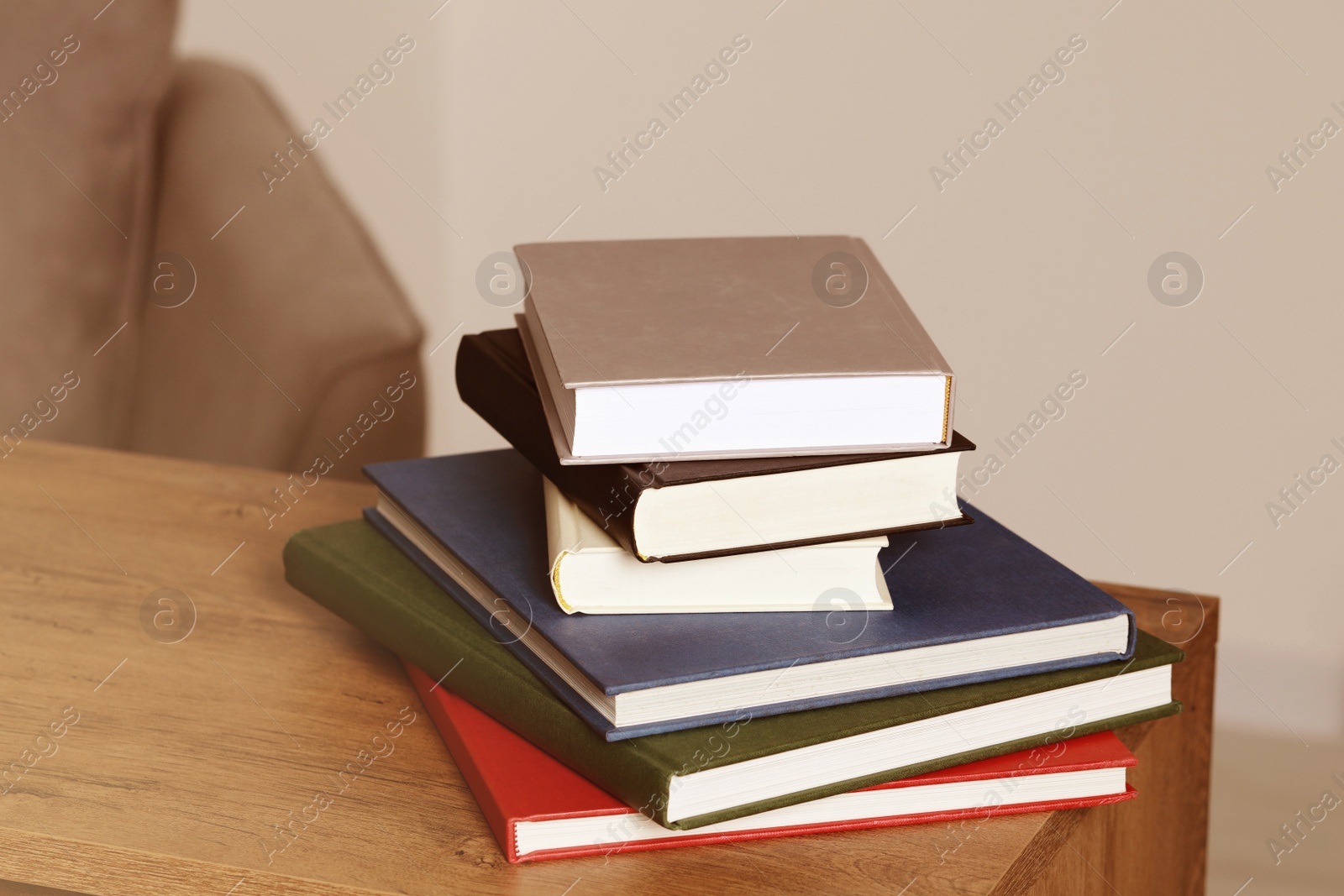 Image of Stack of hardcover books on wooden table indoors