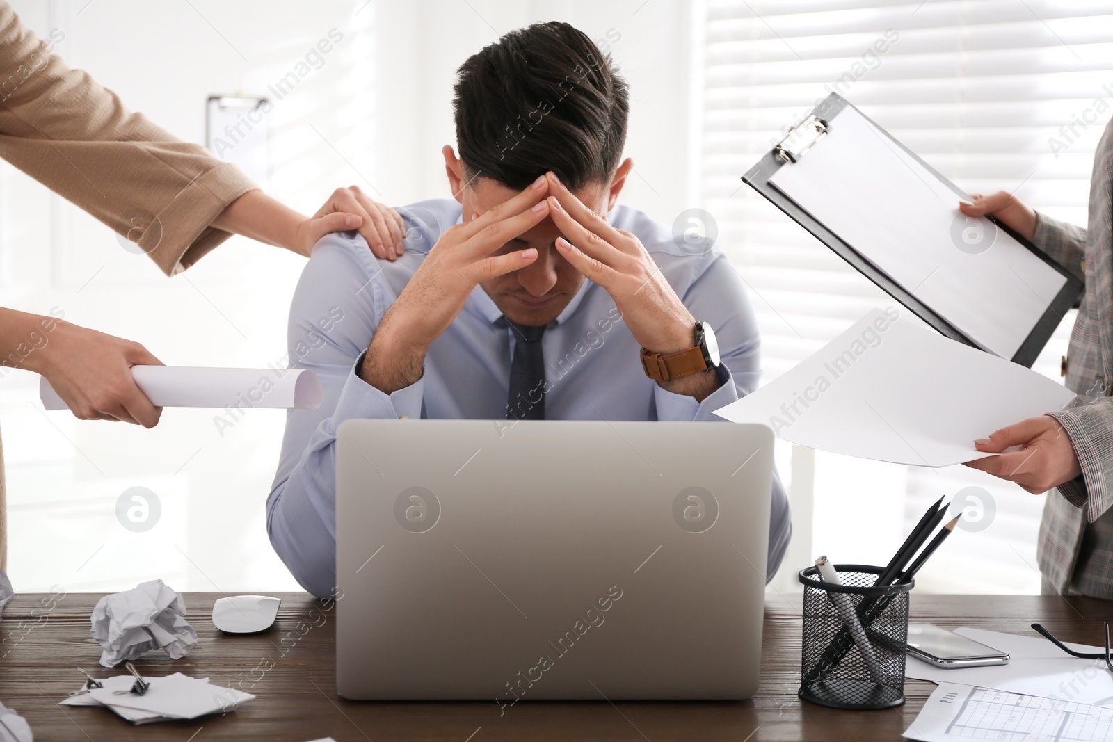 Photo of Businessman stressing out at workplace in office