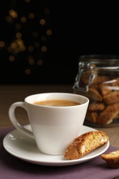 Photo of Tasty cantucci and cup of aromatic coffee on wooden table. Traditional Italian almond biscuits