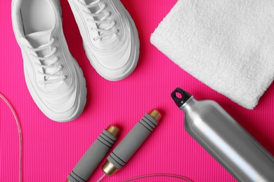 Photo of Flat lay composition with fitness equipment on color background