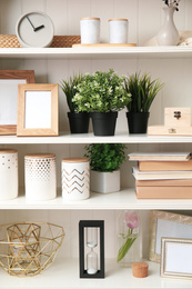 White shelving unit with plants and different decorative stuff