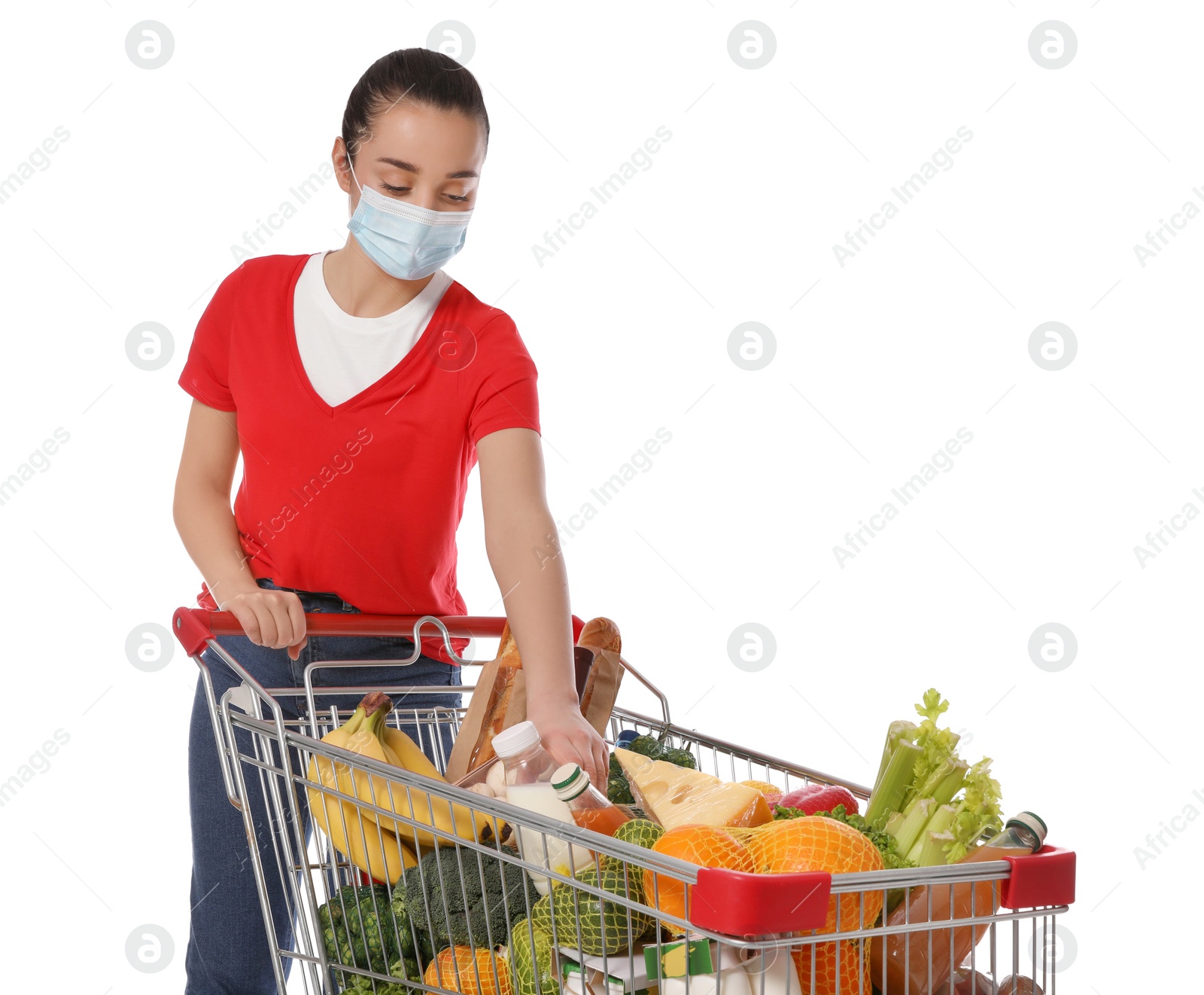 Photo of Woman with protective mask and shopping cart full of groceries on white background