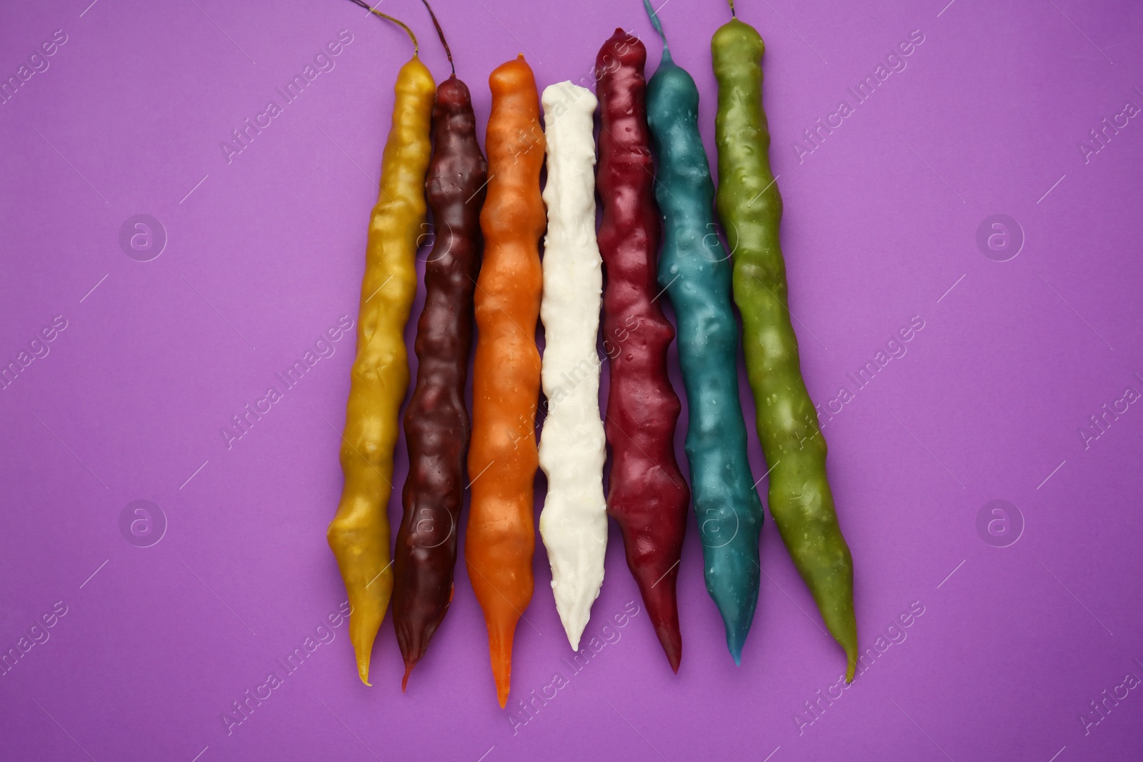 Photo of Many different delicious churchkhelas on purple background, flat lay