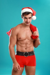 Sexy shirtless Santa Claus on blue background