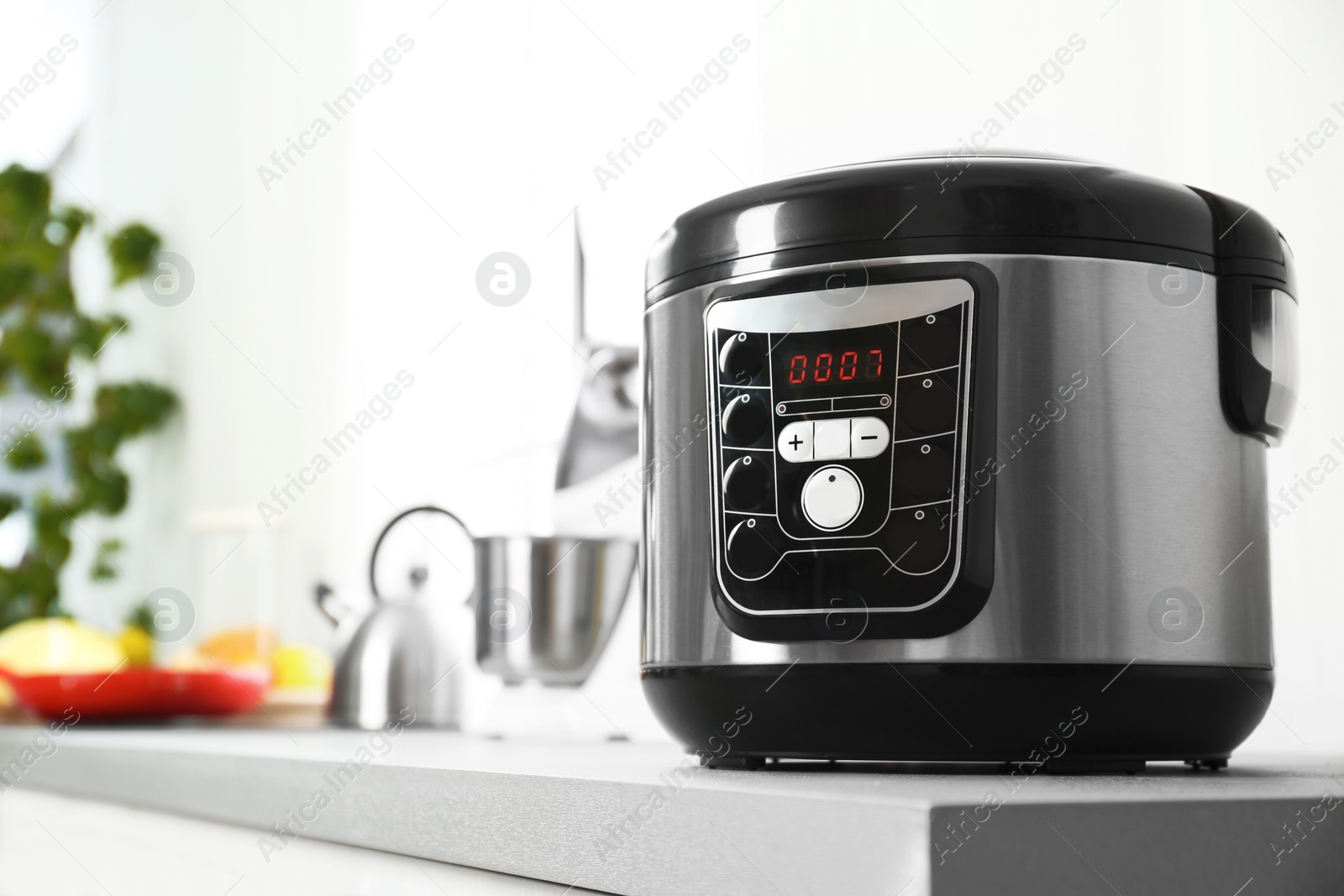 Photo of Modern multi cooker on table in kitchen. Space for text