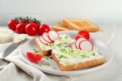 Photo of Toasted bread with cream cheese and vegetables on white wooden table