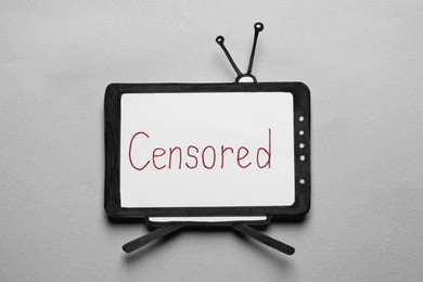 Photo of Paper TV with word Censored on light background, top view