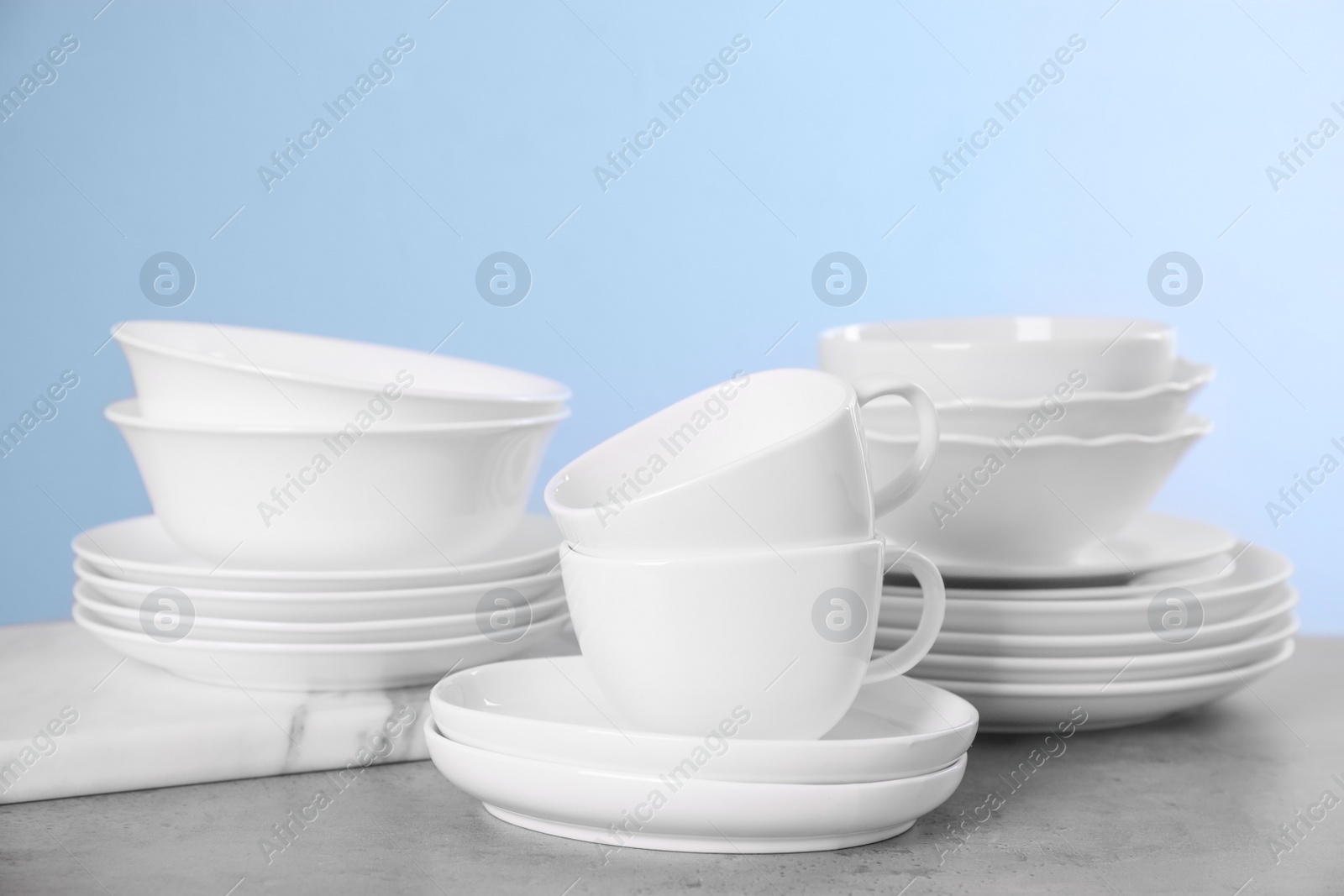 Photo of Set of clean tableware on grey table