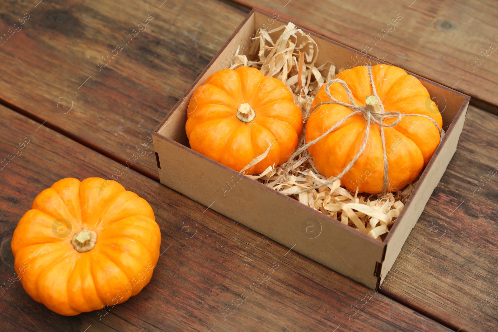 Photo of Crate and ripe pumpkins on wooden table