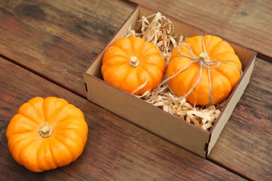 Photo of Crate and ripe pumpkins on wooden table