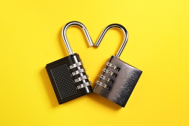 Steel combination padlocks on yellow background, top view