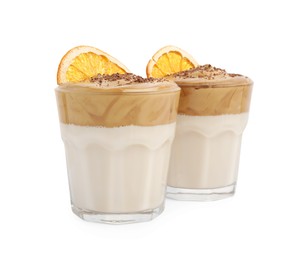 Photo of Glasses of delicious dalgona coffee with dry orange and chocolate isolated on white