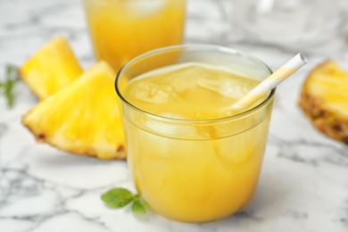 Photo of Glass with delicious pineapple juice on table