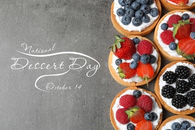 Image of National Dessert Day, October 14. Tasty tartlets with different fresh berries on grey table, flat lay