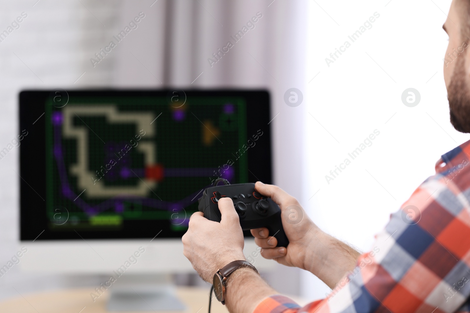 Photo of Young man playing video game at home, closeup