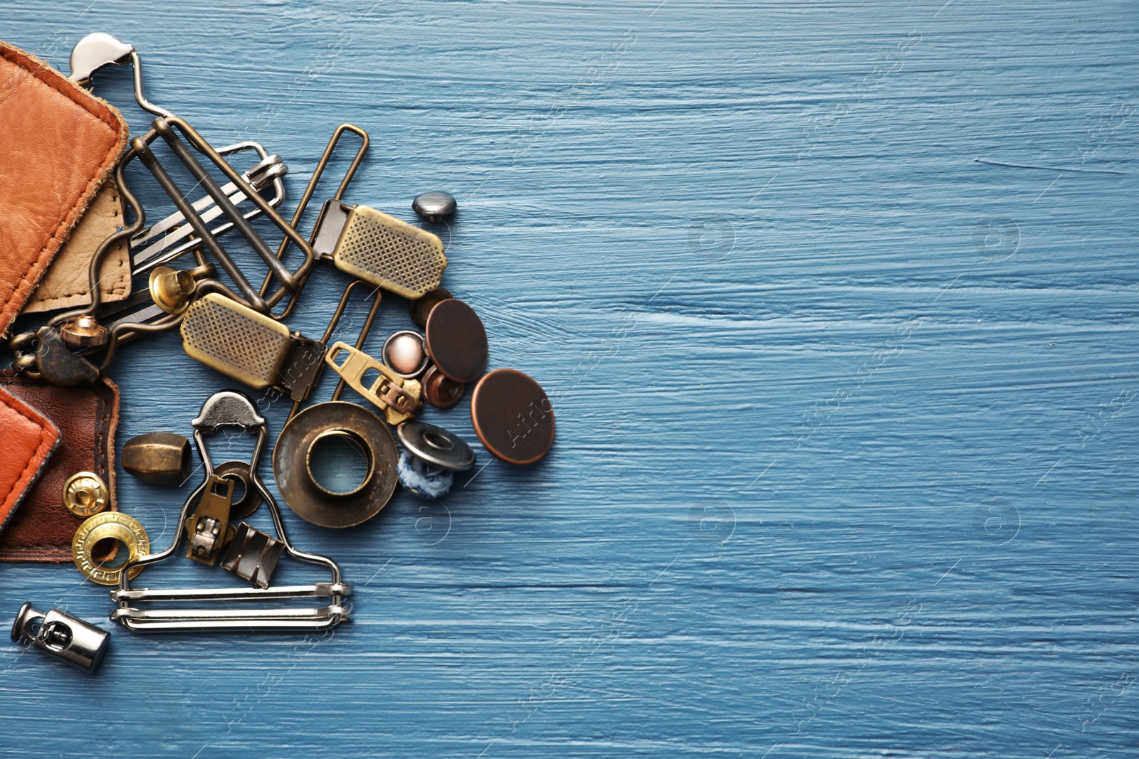 Photo of Flat lay composition with garment accessories for jeans on light blue wooden background. Space for text