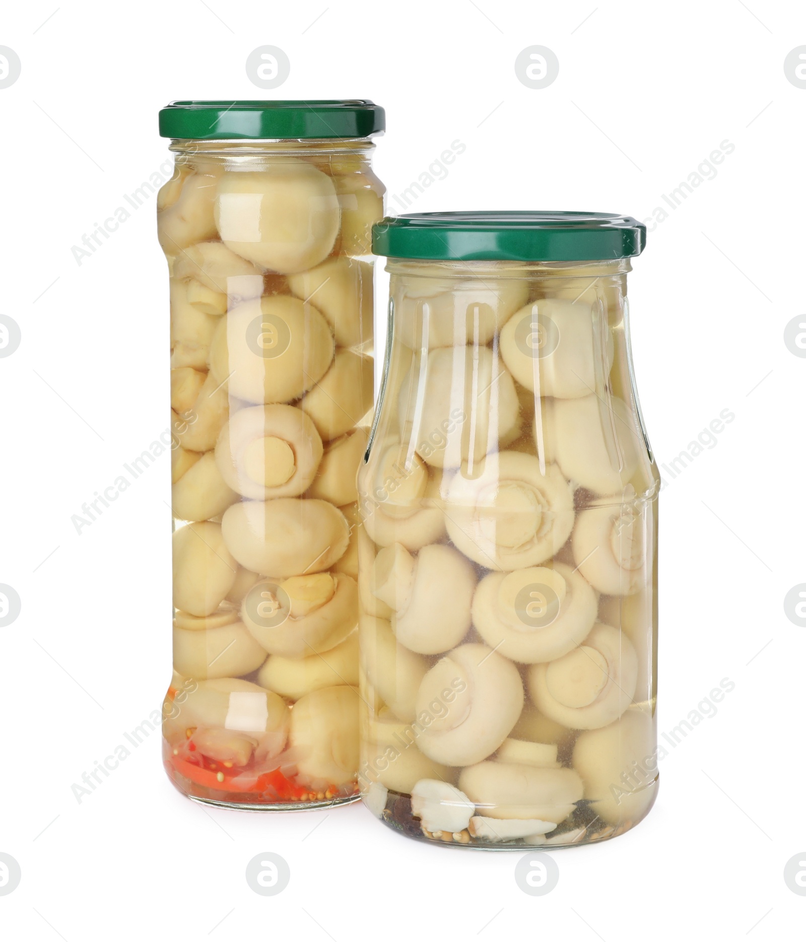 Photo of Jars with marinated mushrooms on white background