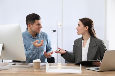 Businesswoman helping intern with work in office