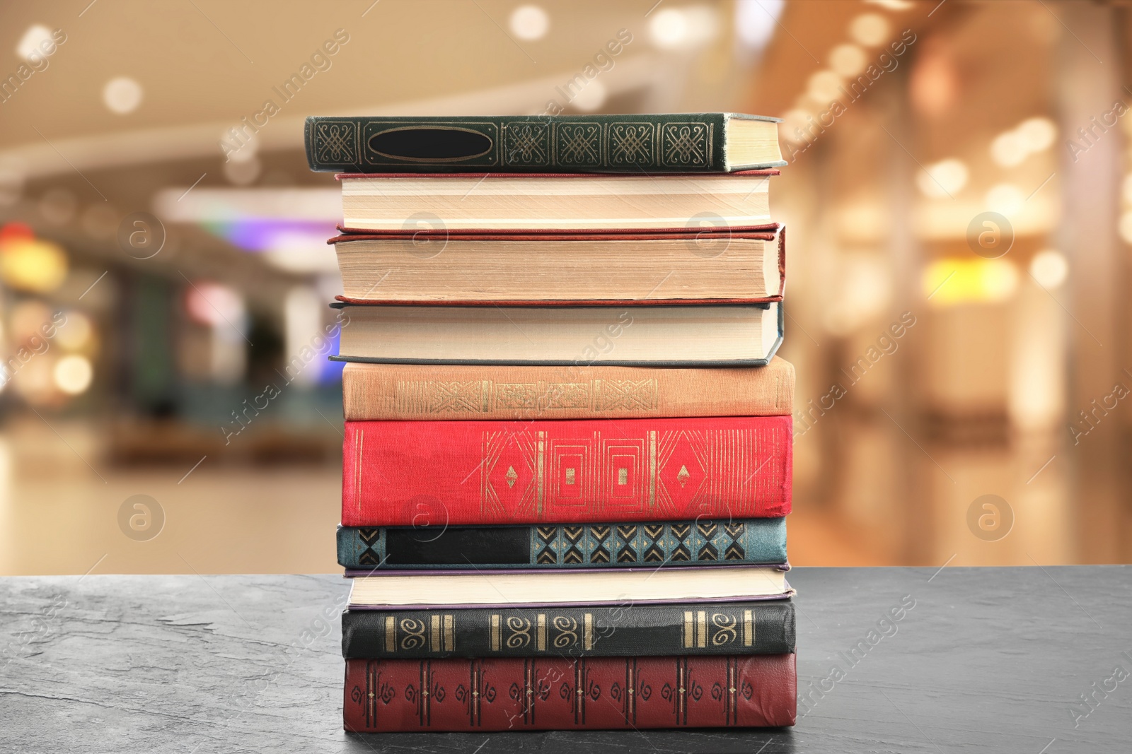 Image of Collection of different books on table against blurred background