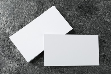 Blank business cards on grey table, flat lay. Mockup for design