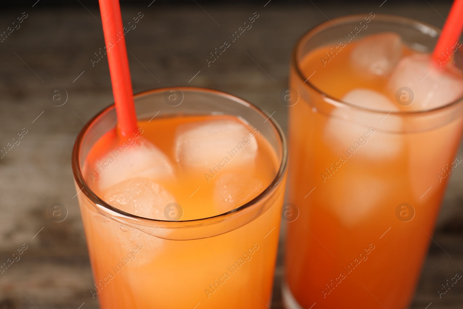 Photo of Tasty freshly made grapefruit juice on table, closeup