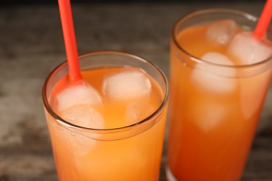 Photo of Tasty freshly made grapefruit juice on table, closeup