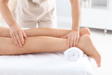 Photo of Woman receiving leg massage in wellness center, closeup