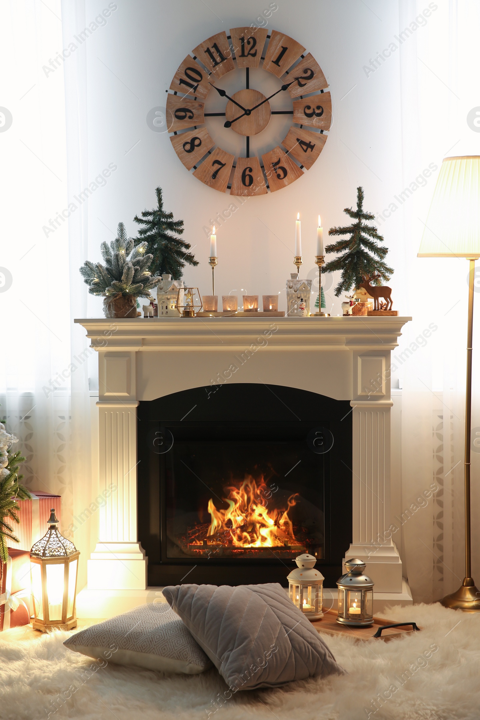 Photo of Small fir trees and candles on mantelpiece indoors. Christmas interior design