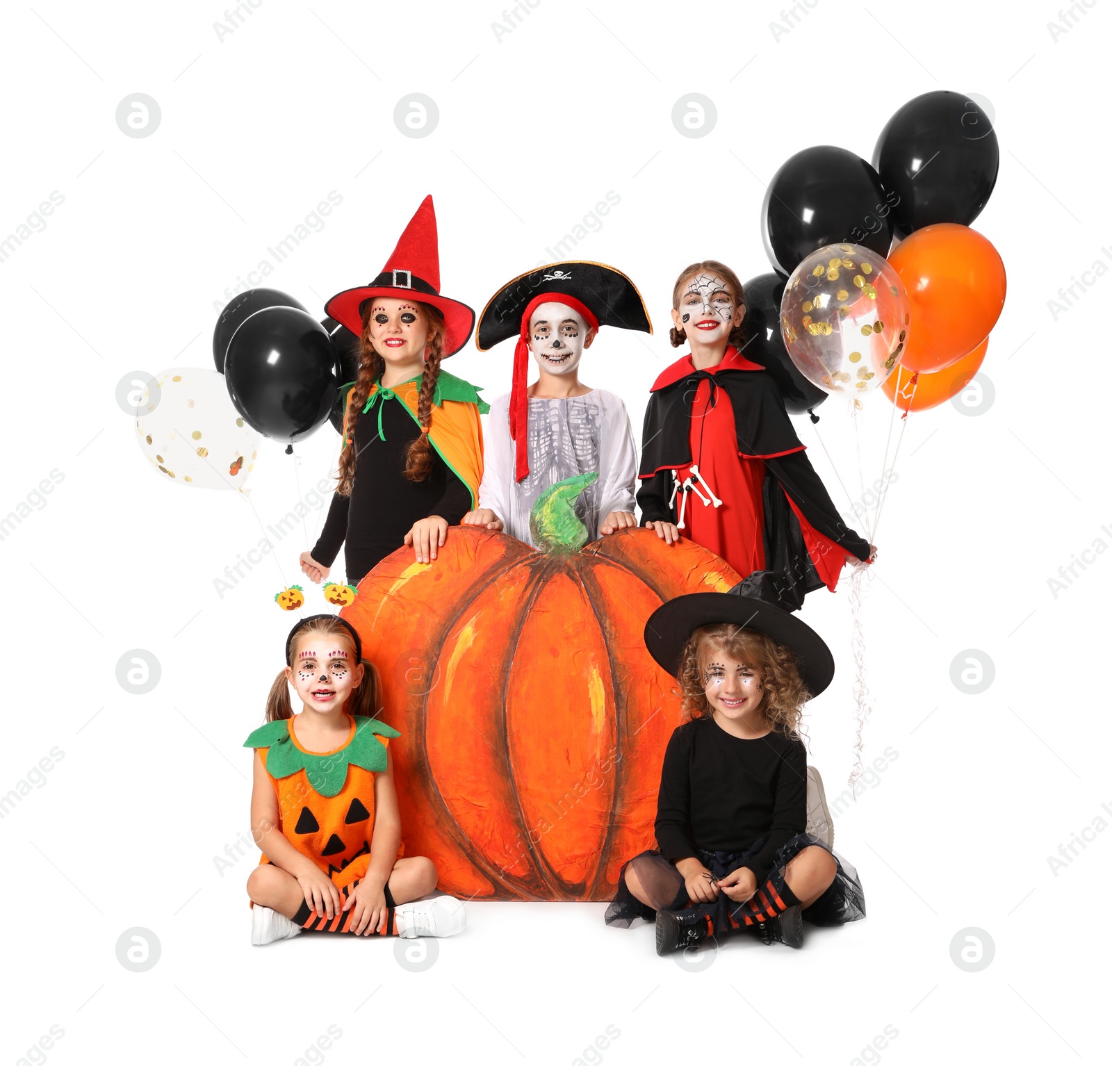 Photo of Cute little kids with balloons and decorative pumpkin wearing Halloween costumes on white background