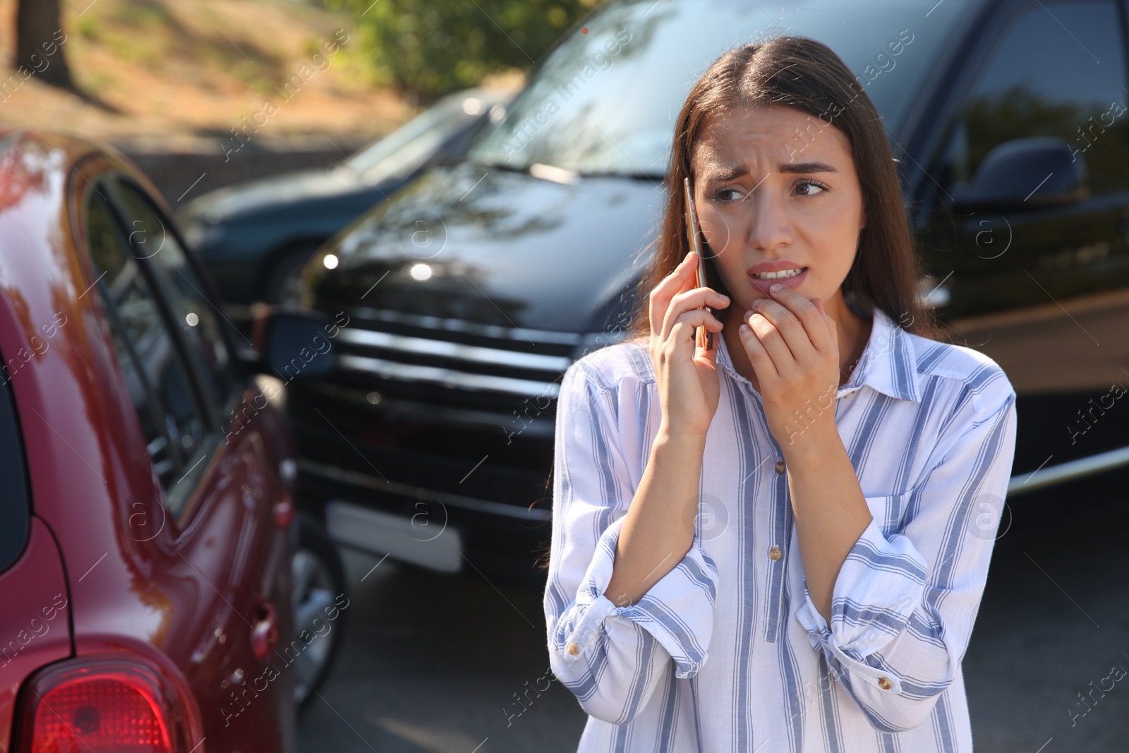 Photo of Stressed woman talking on phone after car accident outdoors