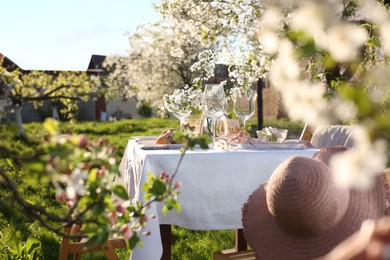 Photo of Beautiful table setting with spring flowers in garden on sunny day