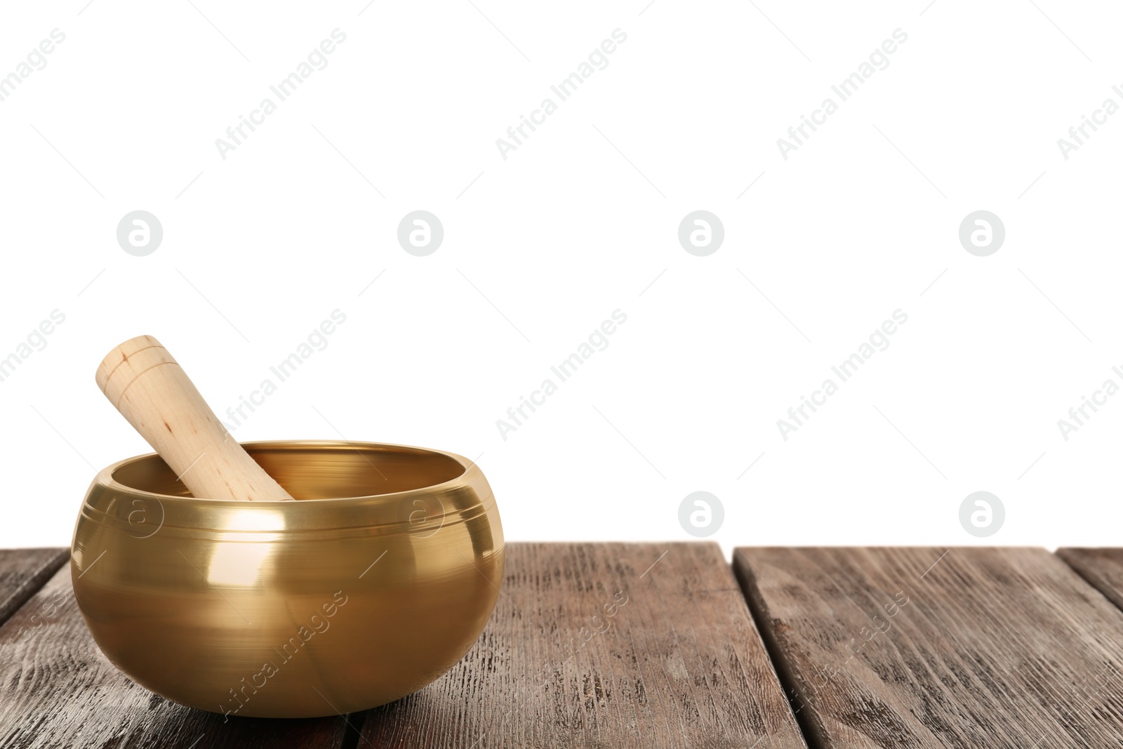 Photo of Golden singing bowl and mallet on wooden table against white background, space for text