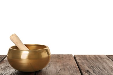 Photo of Golden singing bowl and mallet on wooden table against white background, space for text