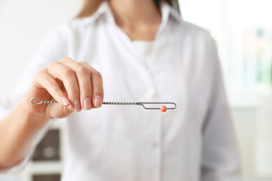 Photo of Speech therapist with logopedic probe in clinic, closeup