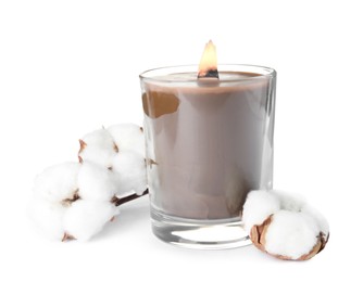 Beautiful candle with wooden wick and cotton flowers on white background