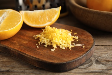 Lemon zest and fresh fruits on wooden table, closeup