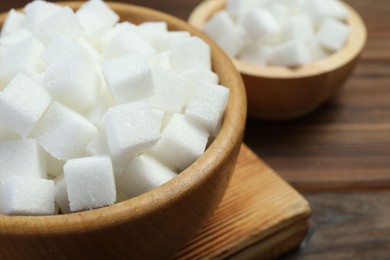 White sugar cubes on wooden table, closeup