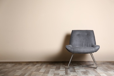 Photo of Stylish chair near color wall, space for text. Interior design