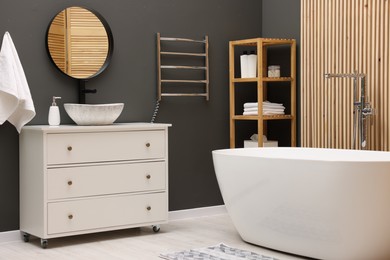 Photo of Stylish bathroom interior with heated towel rail and modern furniture