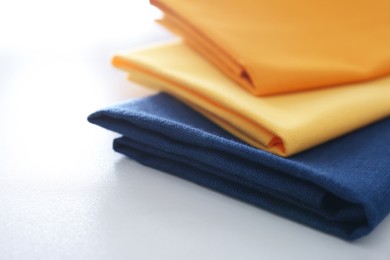 Photo of Different colorful napkins on white table, closeup