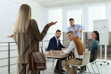Photo of Businessman scolding employee for being late on meeting in office