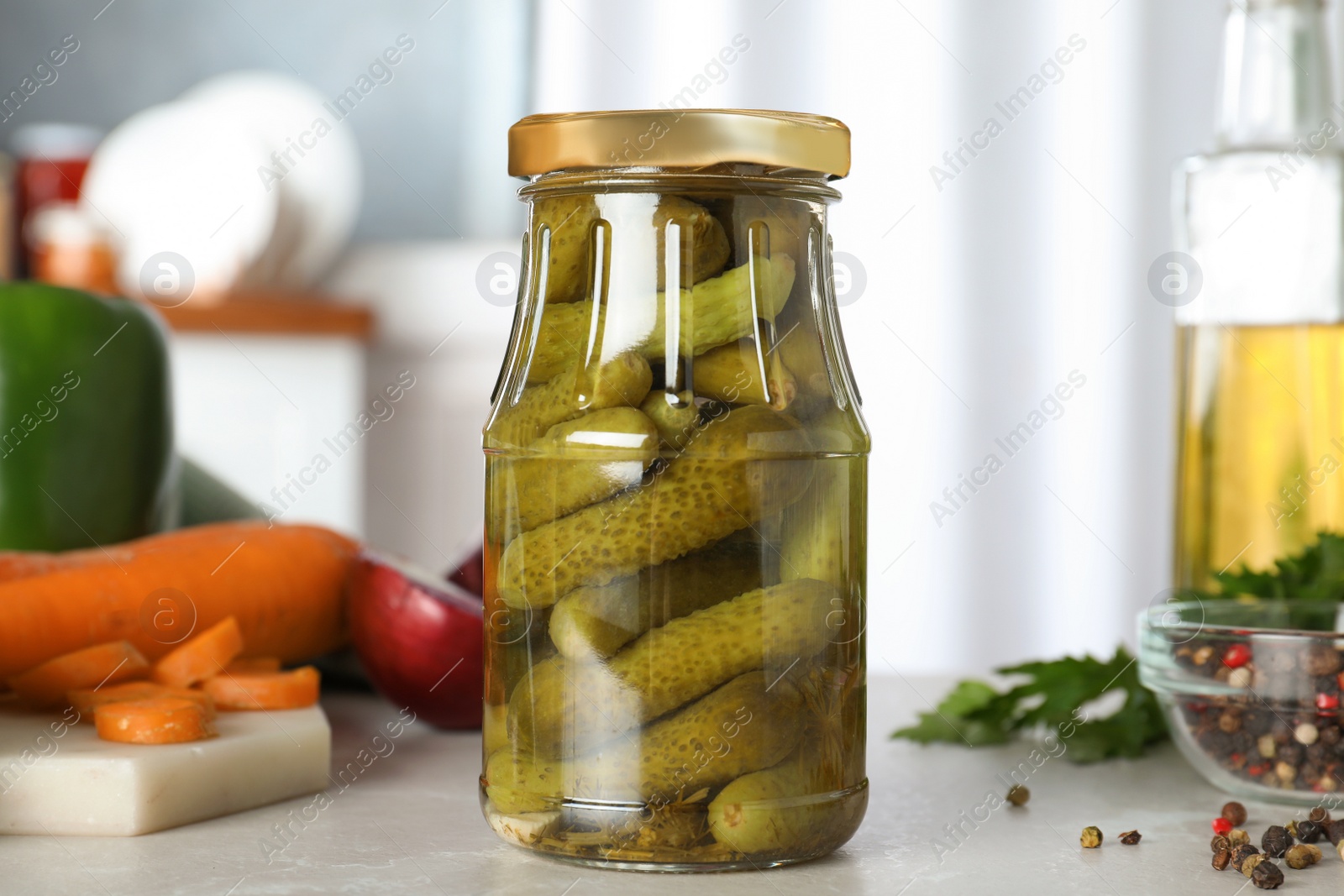 Photo of Glass jar of pickled cucumbers on marble table