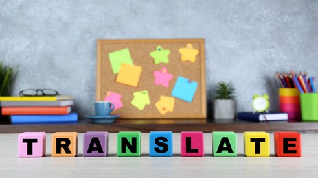 Photo of Word Translate made of colorful cubes with letters on white wooden table