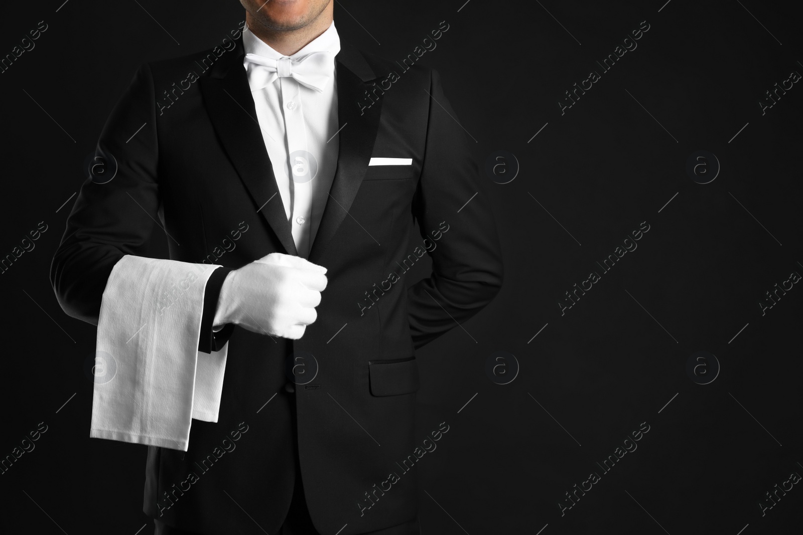 Photo of Butler with towel on black background, closeup. Space for text